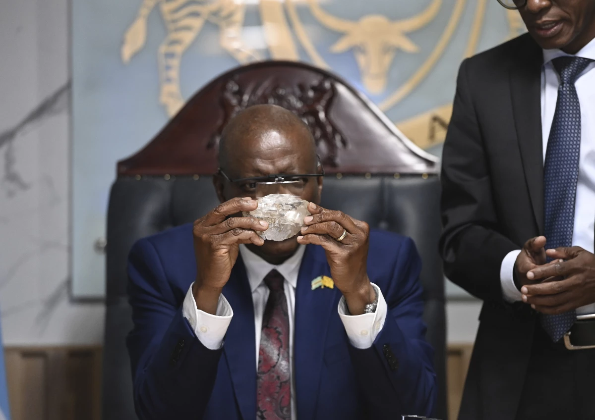 Botswana's President Mokgweetsi Masisi holds the 2,492-carat diamond that was unearthed at one of its mines and will be put on show, on Thursday, Aug. 22, 2024, in Gaborone.