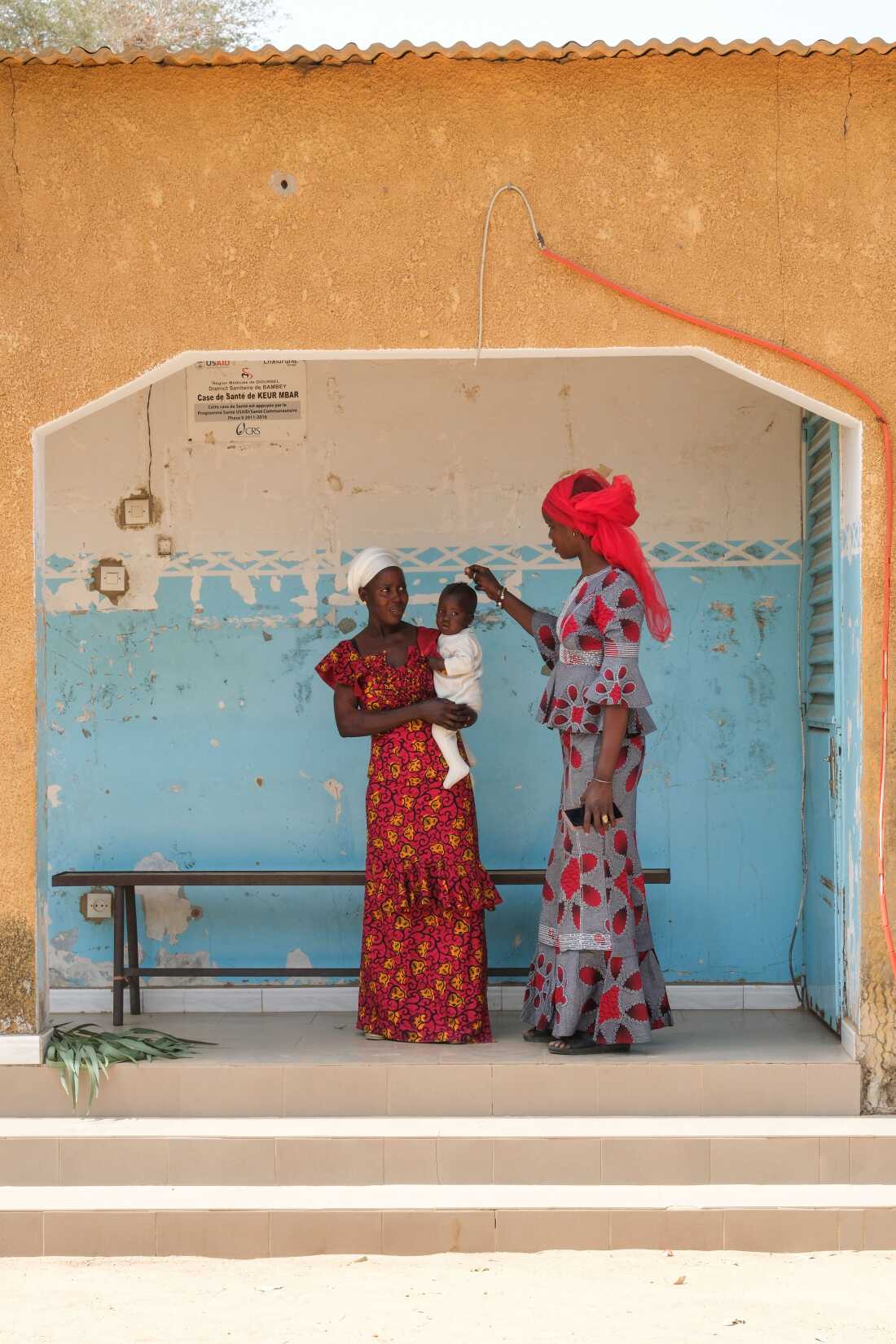 Keur Mbar, Senegal (May 4, 2026) - Adama Faye, a community healthworker, with Ndiolle Diouf and her son Aliou Faye, t at the village's health hut.