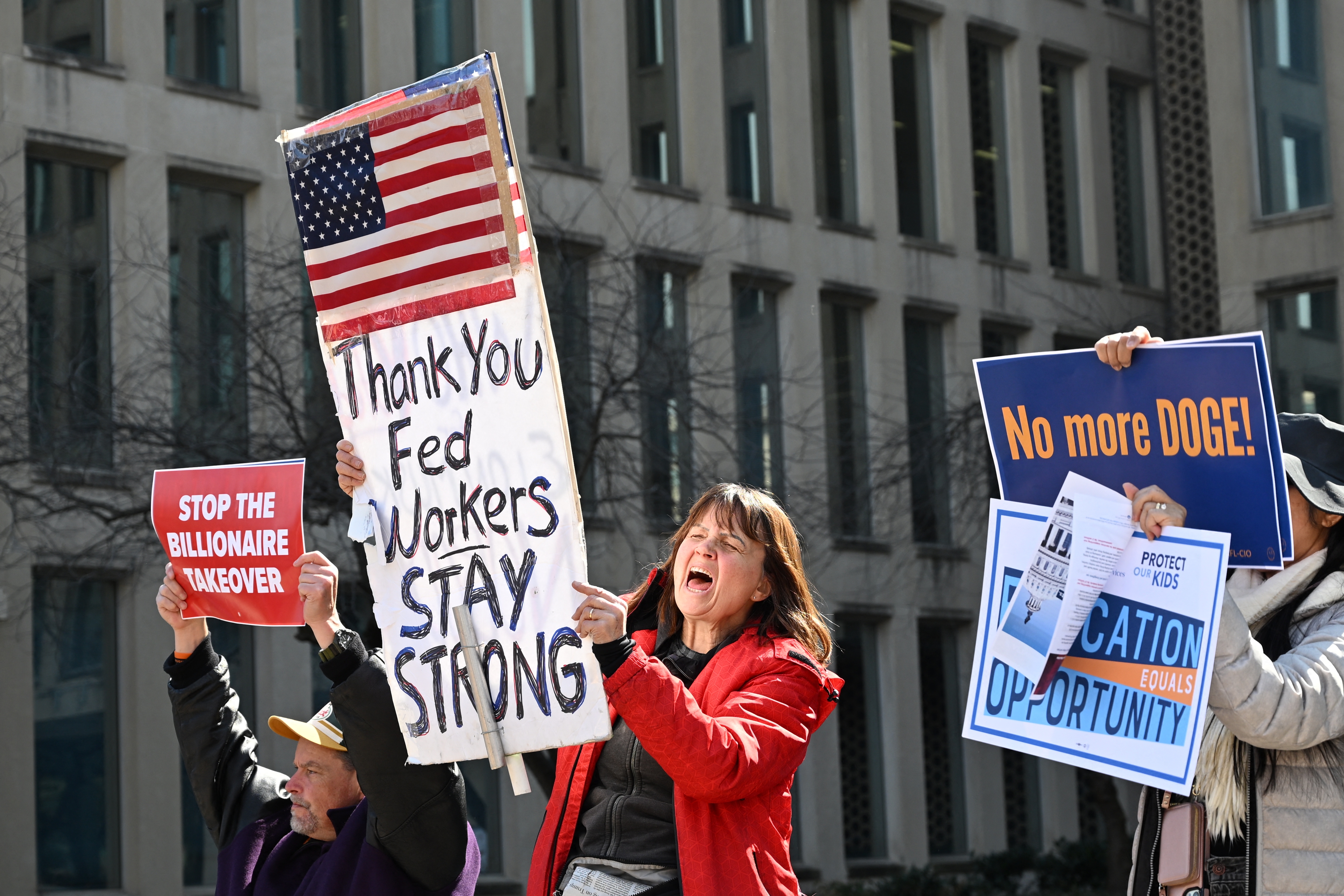 Protesters hold signs in solidarity at a rally in support of federal workers at the Office of Personnel Management in Washington, D.C., on March 4.