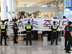 A group of people hold a banner reading