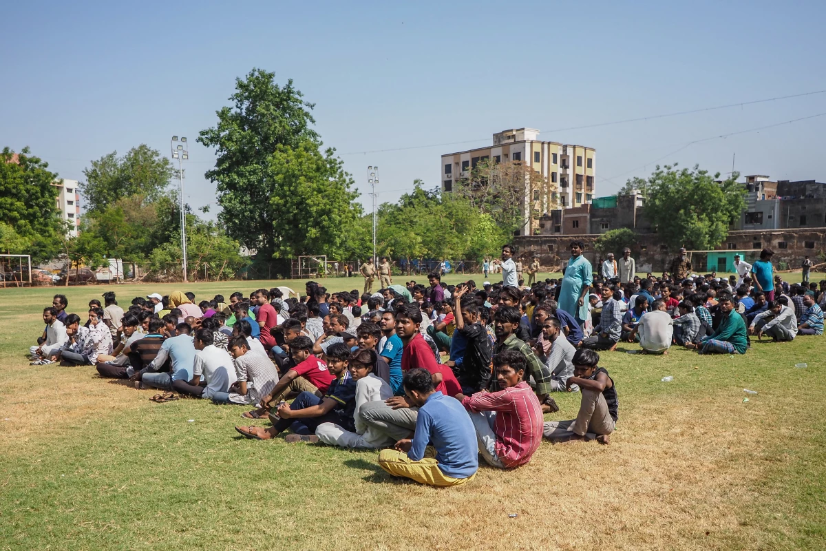 Detained Bangladeshi migrants sit at a crime branch office following an overnight operation by the state police in Ahmedabad, India, on April 26.