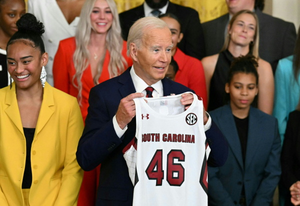 President Biden holds a jersey given to him by the University of South Carolina women's basketball team during a White House event to celebrate their 2023-24 championship season on Sept. 10, 2024.