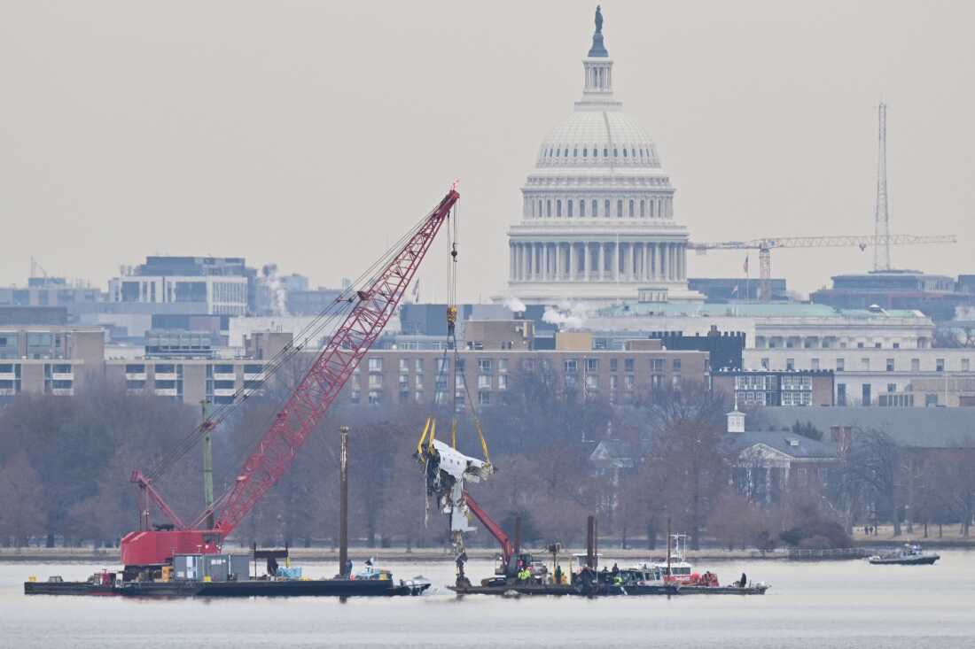 A crane removes airplane wreckage from the Potomac River, where American Airlines flight 5342 collided with a U.S. Army Black Hawk helicopter, near Ronald Reagan Washington National Airport in Arlington, Va., on February 3, 2025. All 67 people on both aircraft died.