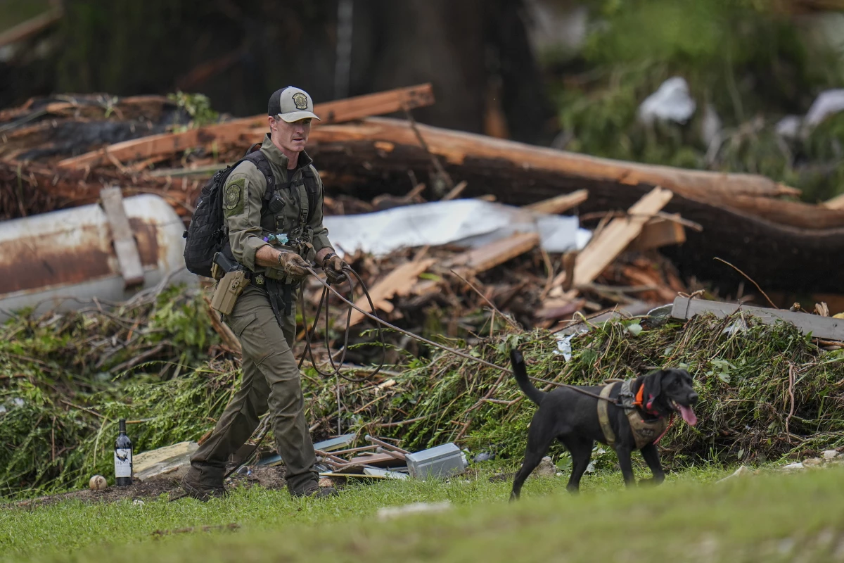 Officials comb through the banks of the Guadalupe River after a flash flood swept through the area in Hunt, Texas.