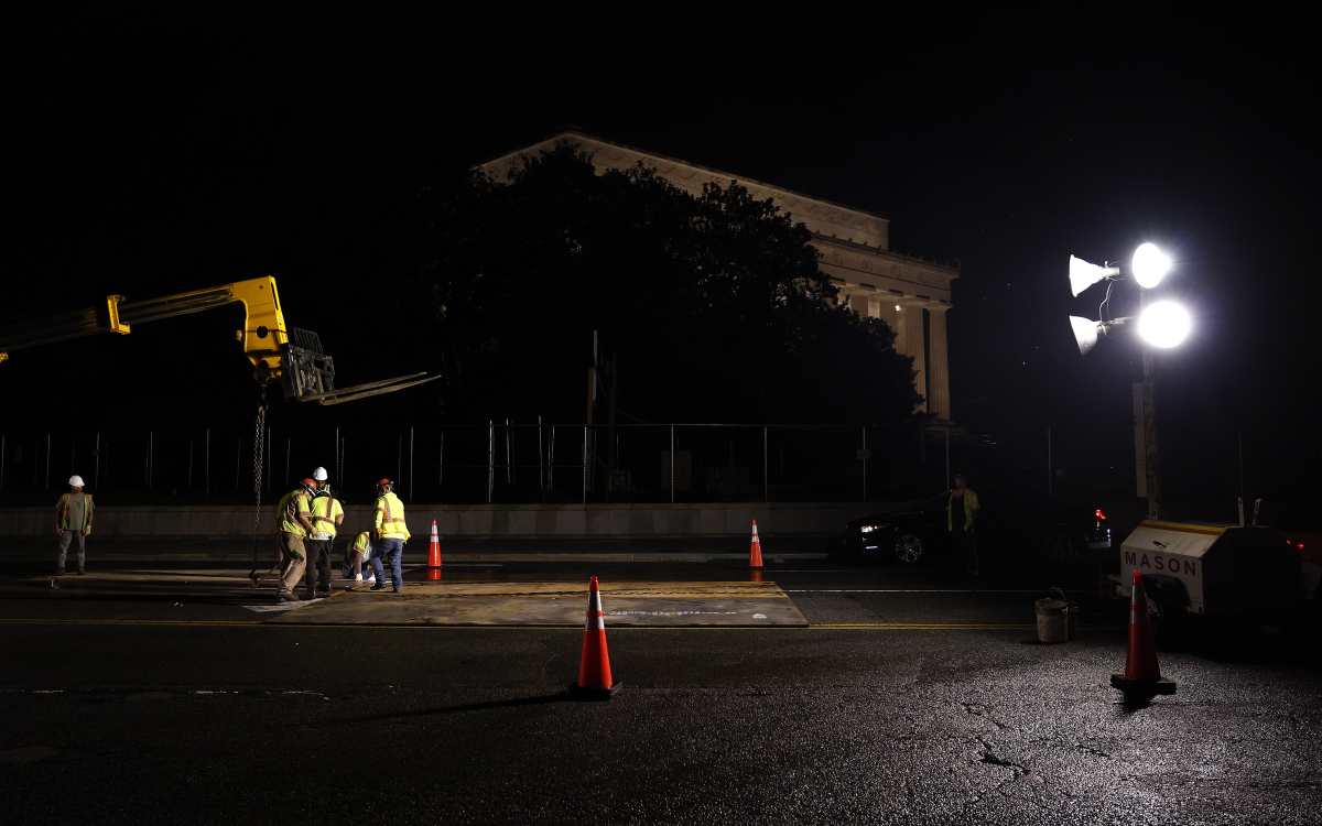 Crews install metal plates to help protect the street from tank damage for the upcoming military parade on June 10 in Washington, D.C.