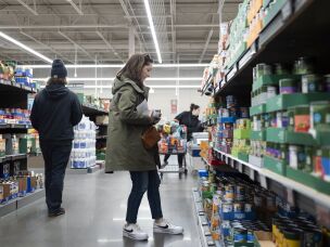 Negro-Henderson looks over canned goods while grocery shopping.