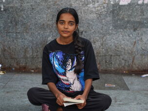 Shalini Yadav, 20, who is seeking treatment at the hospital for an intestinal illness that she's suffered from for five to six years, passes the time reading <em>The God of Sins</em>.