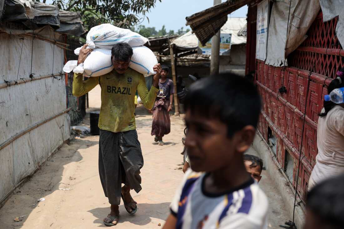 A man carries sacks on his shoulders in a Rohingya refugee camp in Cox’s Bazar, Bangladesh, April 21, 2026.