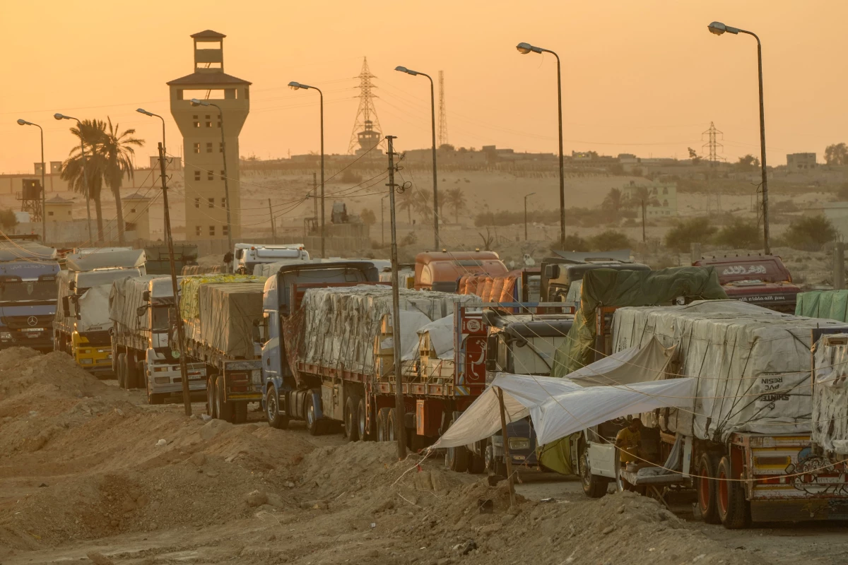 Trucks of humanitarian aids wait to cross the Rafah border crossing between Egypt and the Gaza Strip, in Rafah, Egypt, Monday, Sept. 9, 2024.