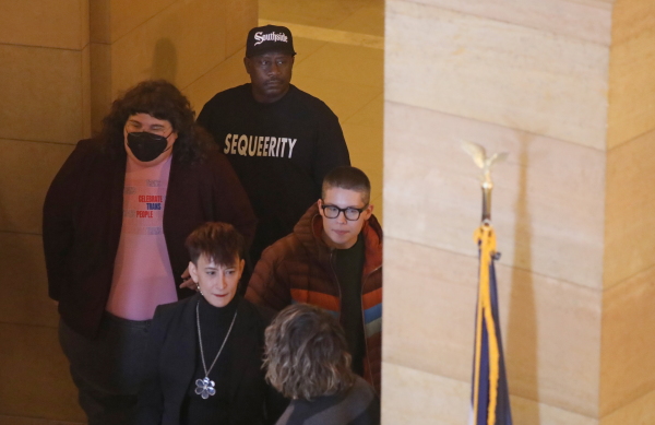 Kim Austell watches over a press conference as the group Sequeerity monitors for any confrontations at the Minnesota State Capitol in Saint Paul, Minn., Dec. 3.