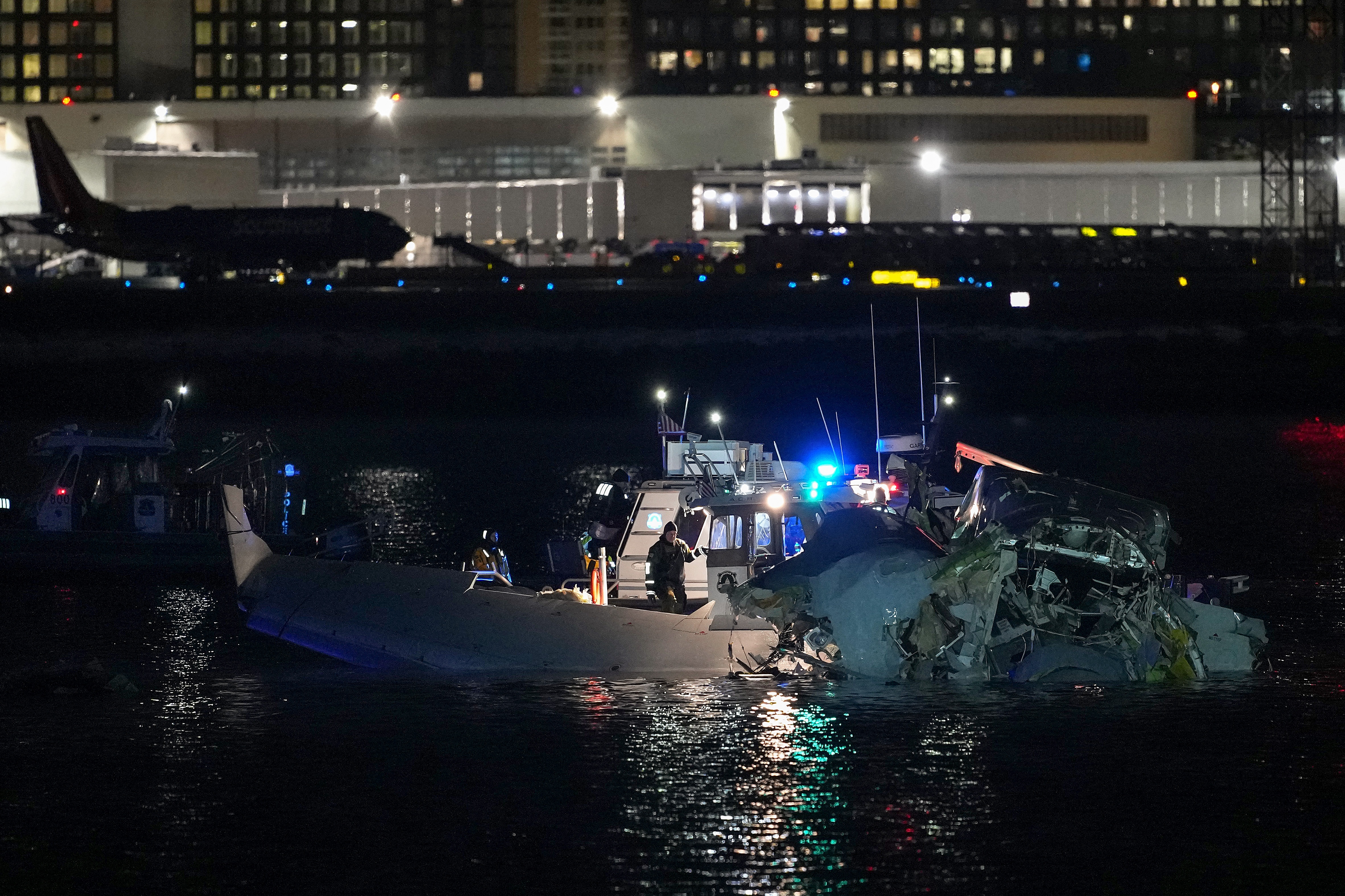 Emergency response units assess airplane wreckage in the Potomac River near Ronald Reagan Washington Airport on January 30, 2025 in Arlington, Virginia. An American Airlines flight from Wichita, Kansas collided with a helicopter while approaching Ronald Reagan National Airport.