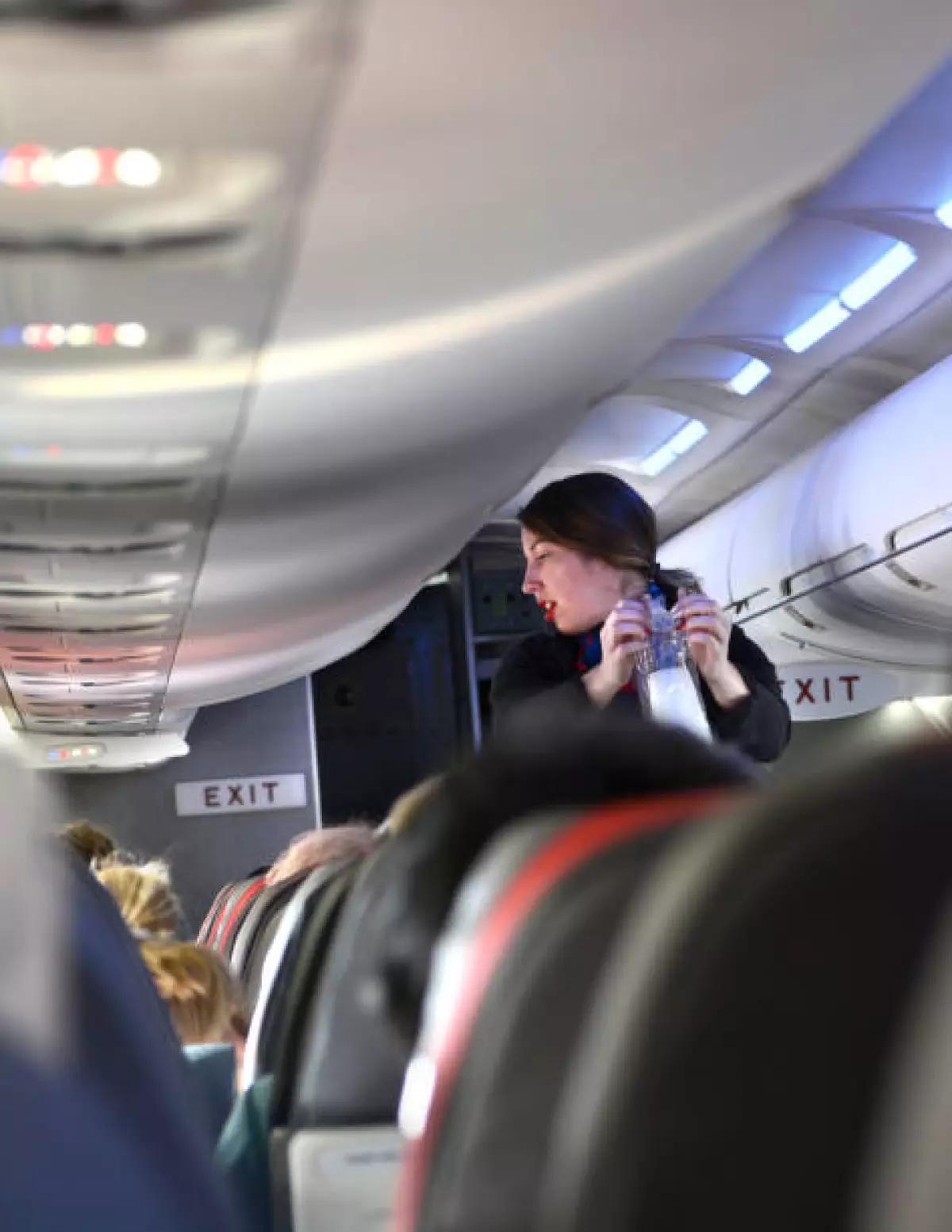 An American Airlines flight attendant serves drinks to passengers after departing Dallas/Fort Worth International Airport.