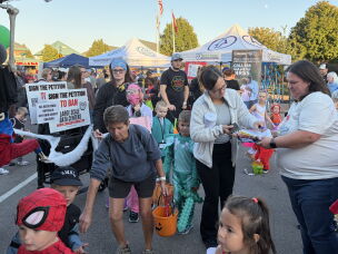 Linda Moodie (right), a volunteer with Conserve Ohio, collects signatures for a petition to ban large-scale data centers statewide at a Halloween event in Fairfield, Ohio, on Oct. 22, 2026.