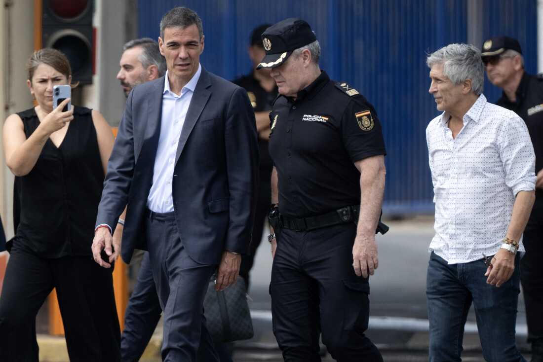 Spain's Prime minister Pedro Sanchez (C) and Minister of Interior Fernando Grande Marlaska (R) walk by the Tarajal border fence between Spain's north Africa's Ceuta enclave and Morocco during a visit to manage one the largest migrant crisis on the country's border as thousands of migrants crossed overnight from Morocco on Friday. In recent days, a total of around 40,000 migrants have crossed into the territory, a police source said, many swimming around the small border barrier that meets with the Mediterranean sea. The sudden massive influx has sparked an international crisis for Spain's government, drawing criticism from Italy and Finland and prompting France to tighten checks on its border with Spain. (Photo by JORGE GUERRERO / AFP via Getty Images)