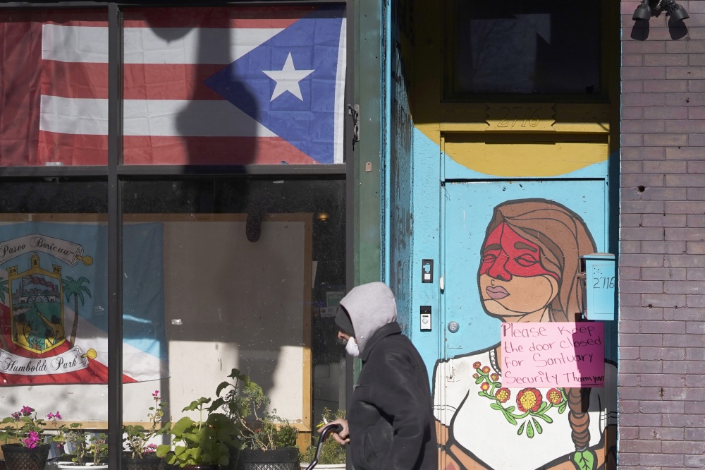 A pedestrian walks past the flag of Puerto Rico and the colorful door to the sanctuary apartment of Chicago's Adalberto Memorial United Methodist Church in Chicago in 2021. The church has provided shelter to immigrants in the U.S. illegally. (AP)