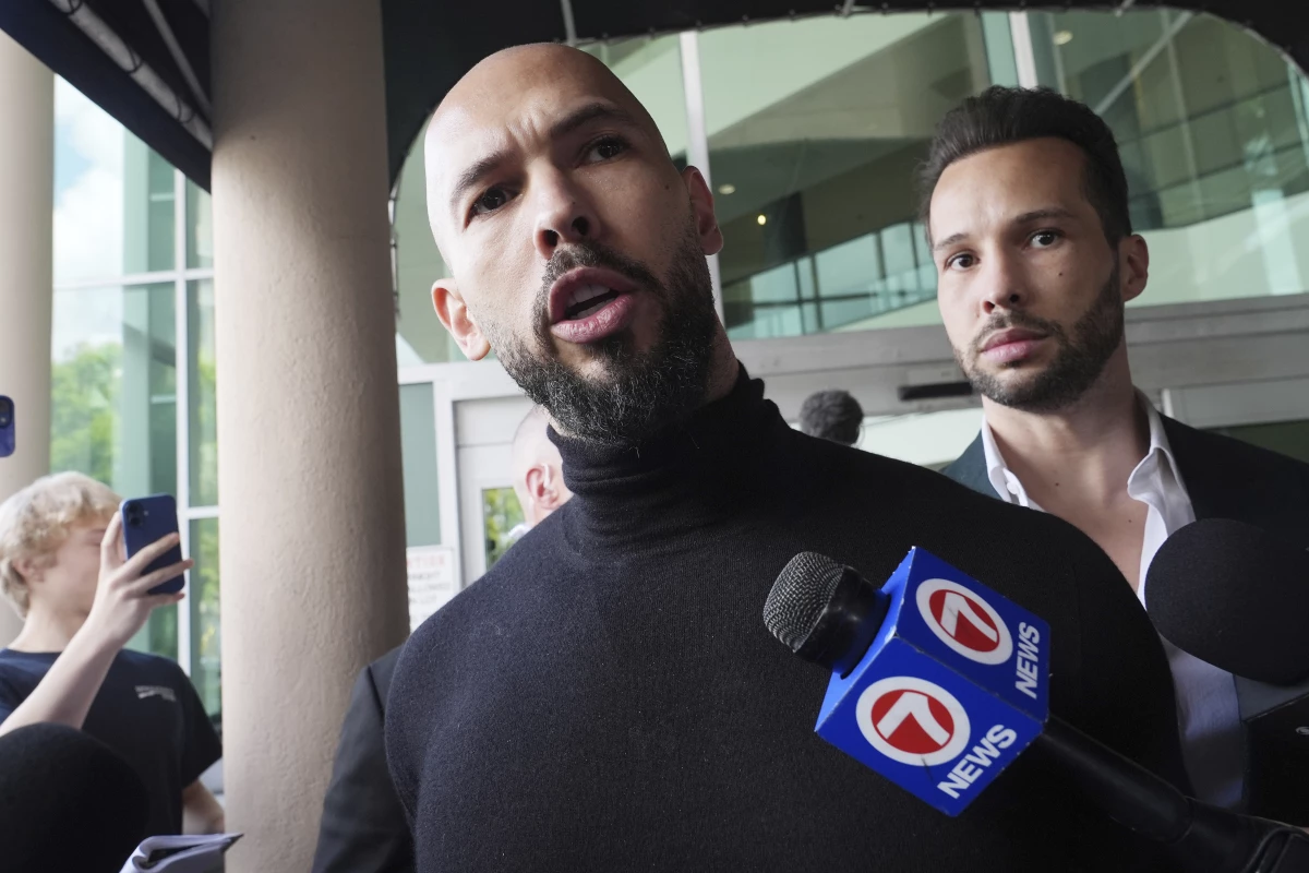 Andrew Tate (foreground) and his brother Tristan arrive in Fort Lauderdale, Fla., on Thursday, after Romanian authorities lifted travel restrictions against them.