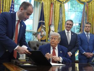 White House staff secretary Will Scharf hands President Donald Trump an executive order to sign regarding nuclear energy in the Oval Office of the White House, Friday, May 23, 2025, in Washington.