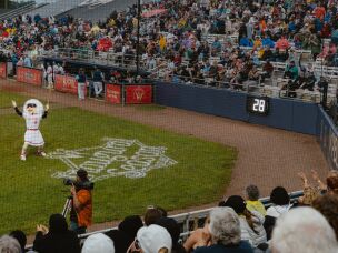 Maybelle the Mascot, designed in honor of veteran baseball player Maybelle Blair, entertains the crowd between innings of the WPBL's opening game on Saturday, Aug. 1.
