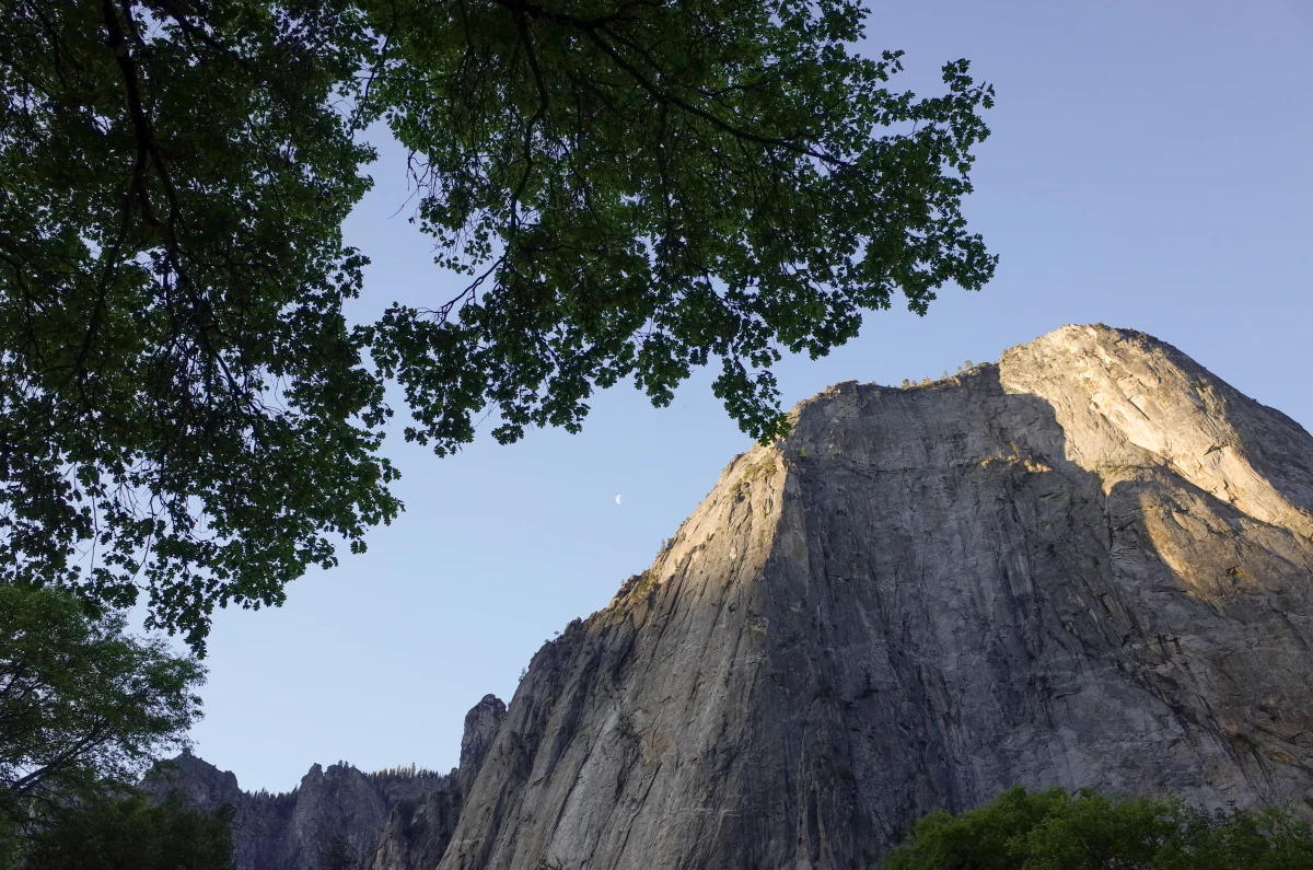 The sun rises over one of the tall, granite monoliths that spring from the Yosemite Valley.