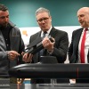 British Prime Minister Keir Starmer (center) and Britain's Defence Secretary John Healey (right) meet with BAE system apprentices as they look at a submarine model during a joint visit on March 20 in Barrow-in-Furness, United Kingdom. Starmer says the U.K. must upgrade its military in response to threats from Russia.