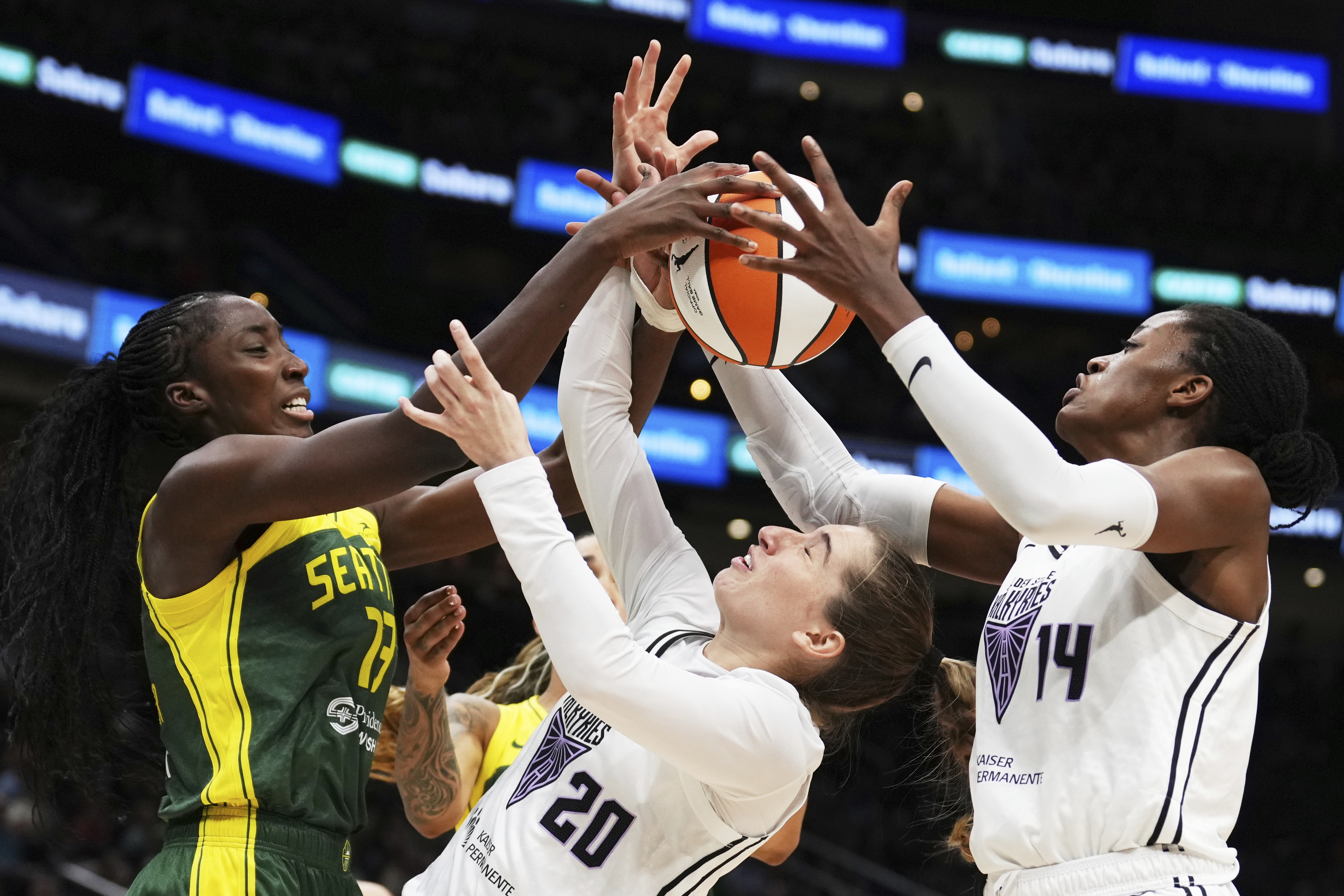 Golden State Valkyries guard Kate Martin (20) struggles to maintain possession against Seattle Storm forward Ezi Magbegor (left) as Valkyries center Temi Fagbenle (14) reaches for the ball during the second half of a WNBA game Wednesday in Seattle. The Valkyries debuted this season as the league