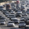 Traffic clogs a highway full of passenger vehicles and tractor-trailers.