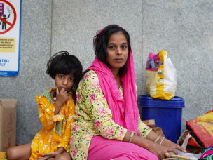 Gulshan Bano, whose mother has heart disease, sits with her 6-year-old daughter, Fiza. They had been staying outside the hospital for the past 10 days while seeking medical treatment for her mother.