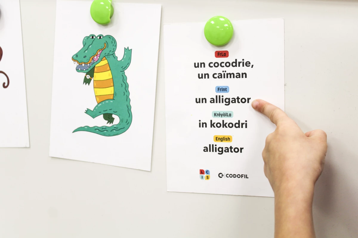 A student points to multiple French words for alligator at École Pointe-au-Chien.