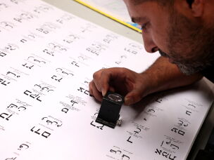A worker uses a loupe to examine ballots at a printing factory, ahead of the Israeli legislative elections in Kiryat Gat, southern Israel, on Oct. 8, 2026.