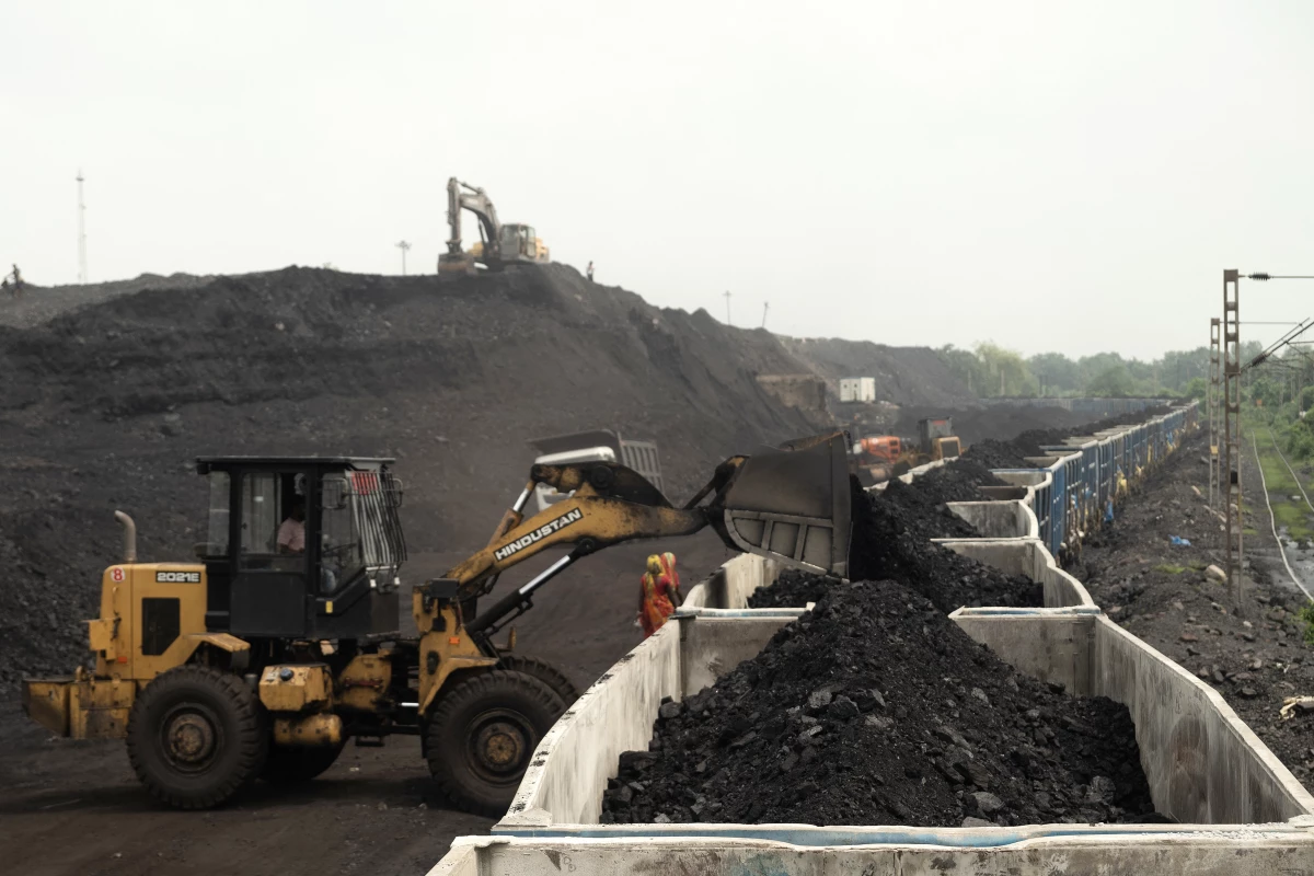 On the outskirts of Dhanbad, in India's Jharkhand state, heaps of coal are loaded onto a train car in August. India is the world's third-largest greenhouse gas polluter and relies heavily on coal for electricity generation.