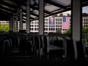 A large banner depicting Trump hangs over the Labor Department building, visible along the racetrack.
