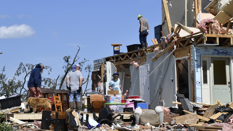 Family members cull through the debris of their home that was destroyed by a severe storm in London, Ky., on Saturday.