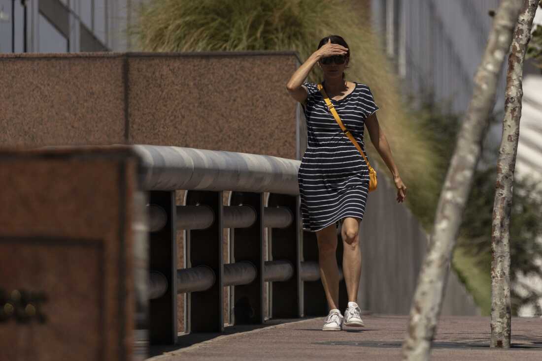 Uma mulher protege os olhos do sol enquanto caminha no centro de Los Angeles durante uma onda de calor na sexta -feira, 6 de setembro de 2024.