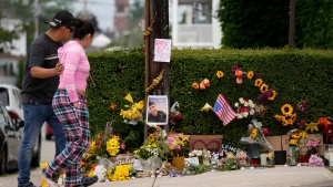 Local residents walk by a makeshift memorial to the victim of a shooting involving U.S. Immigration and Customs Enforcement, Tuesday, July 14, 2026 in Biddeford, Maine.