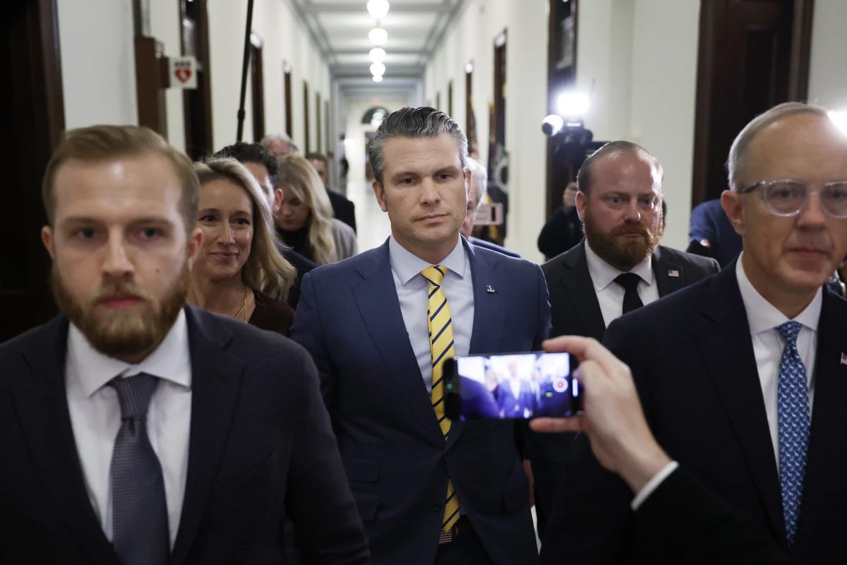 Pete Hegseth, President-elect Donald Trump's nominee to be Secretary of Defense, and his wife Jennifer Rauchet walk through the Russell Senate Office building on Capitol Hill on Dec. 3, 2024.