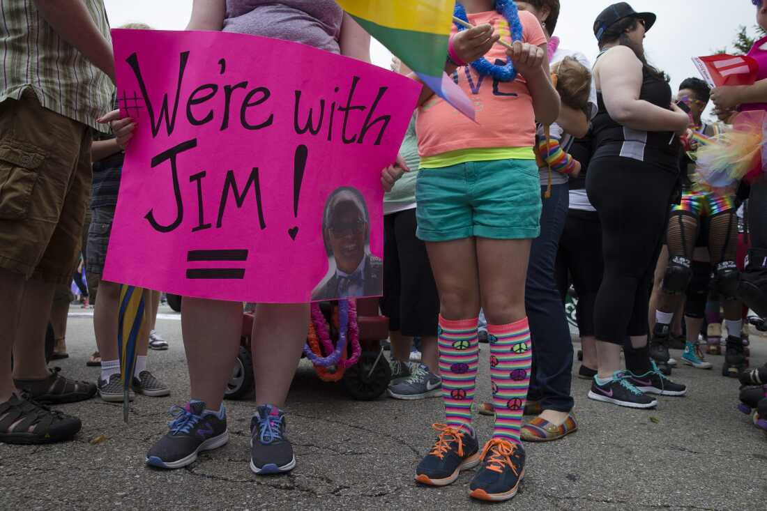 A reveler holds a sign in support of gay marriage plaintiff Jim Obergefell during the Cincinnati Pride parade, Saturday, June 27, 2015.