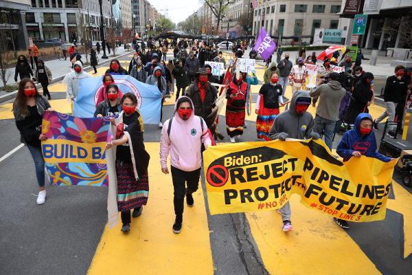 Indigenous environmental activists march through Black Lives Matter Plaza on their way to the White House as part of a protest against oil pipelines on April 1, 2021.