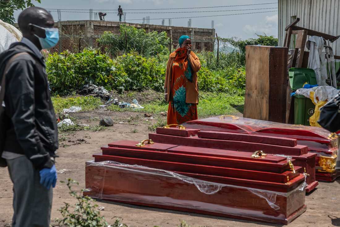 Family members of people who died of Ebola stand next to coffins at a health center in Rwampara, Congo, Wednesday, May 20, 2026.