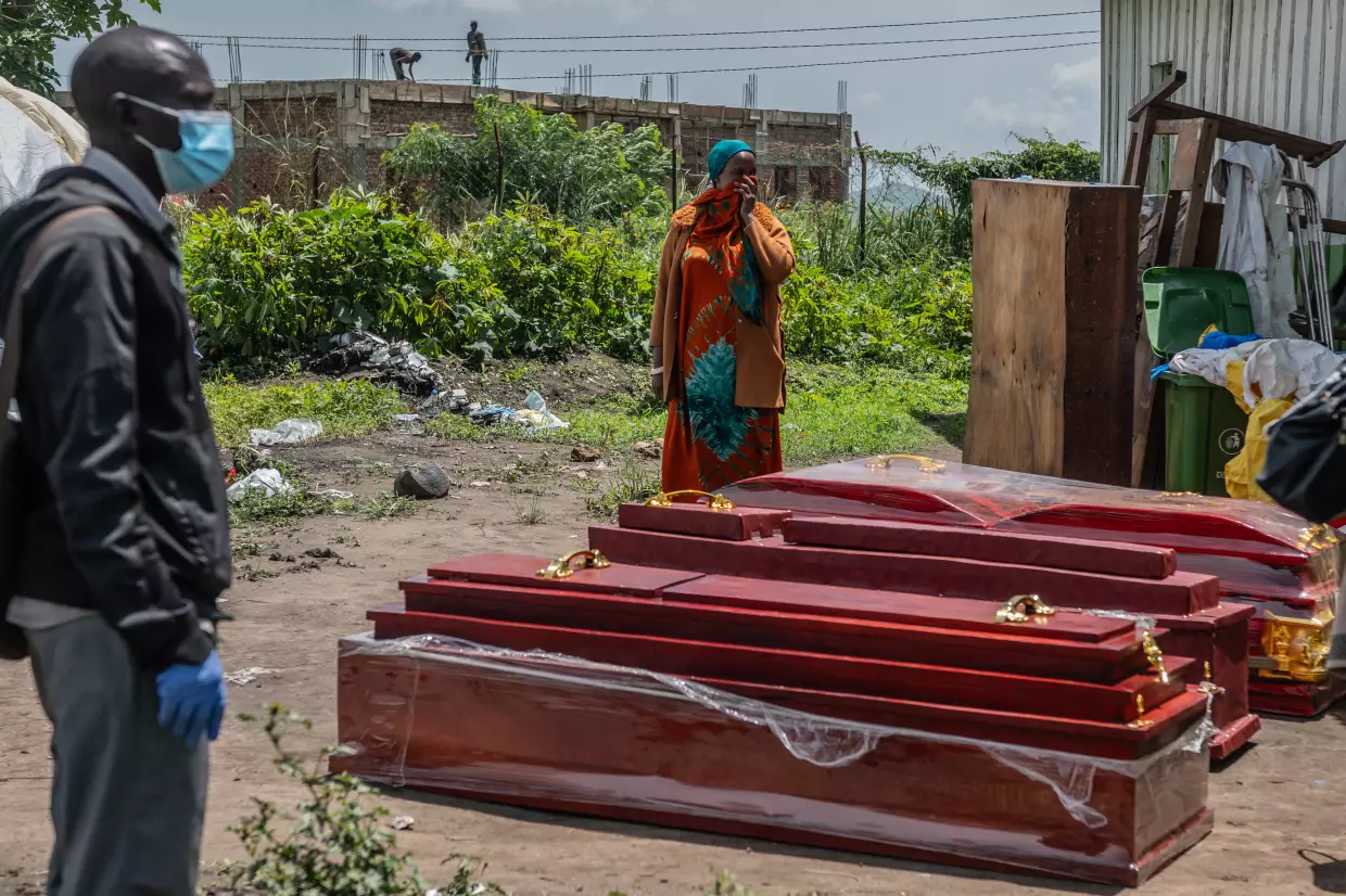 Family members of people who died of Ebola stand next to coffins at a health center in Rwampara, Congo, Wednesday, May 20, 2026.