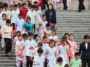 Children holding Russian and Chinese flags walk ahead of a welcoming ceremony for Russian President Vladimir Putin at the Great Hall of the People in Beijing, China Wednesday, May 20, 2026.