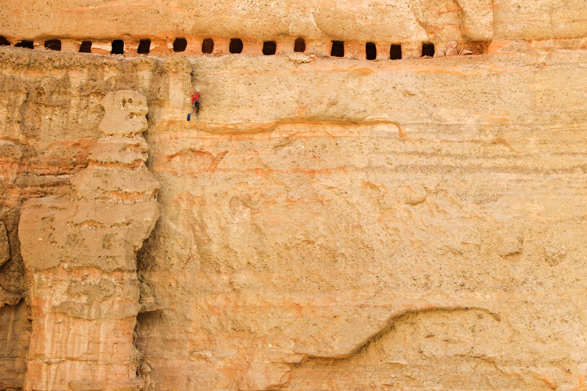 Matt Segal climbs into an ancient cave complex below the village of Tsele, Mustang, Nepal, 2011.
