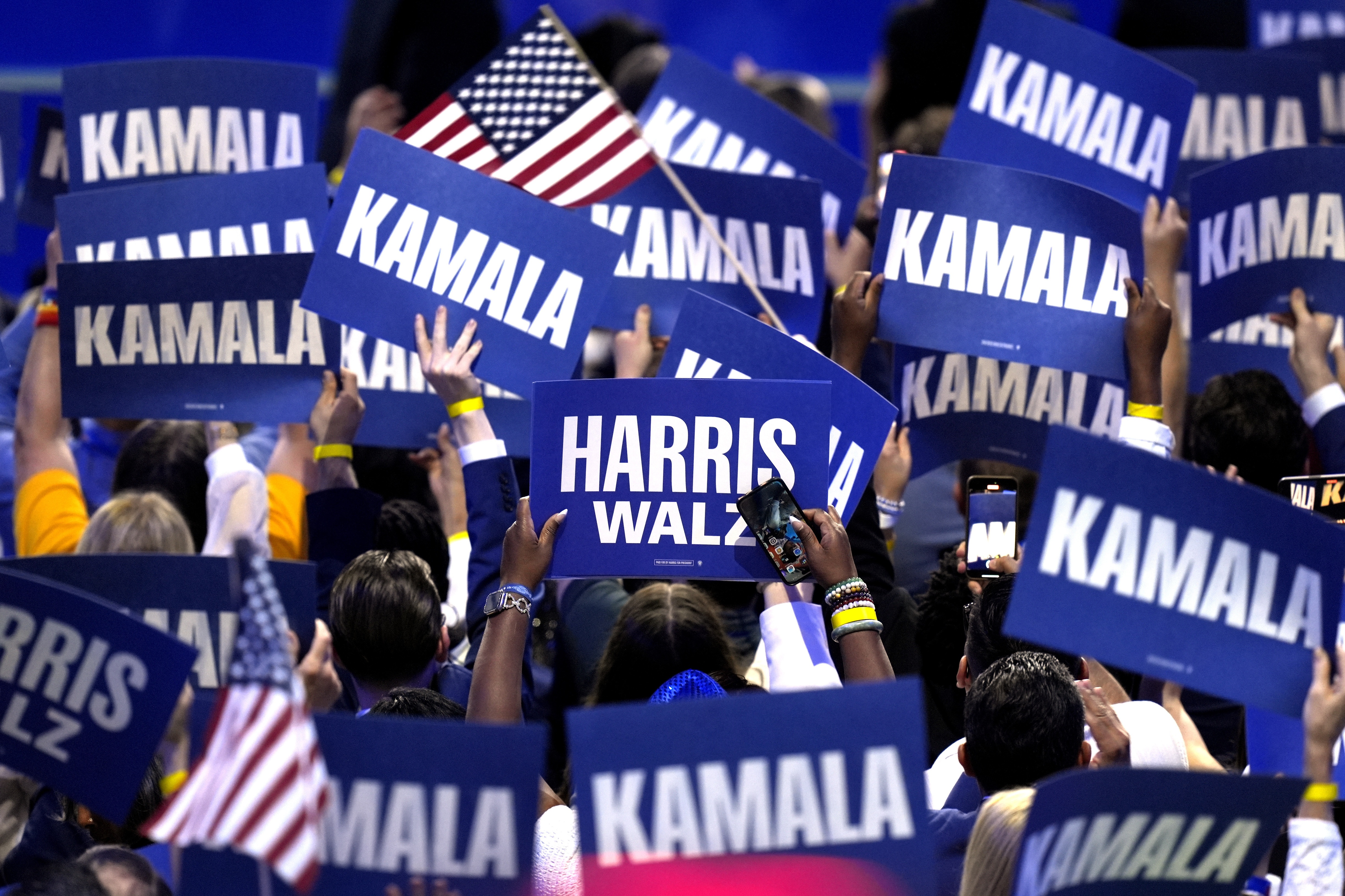 Supporters carry signs as Democratic presidential nominee Vice President Kamala Harris speaks during the Democratic National Convention on Aug. 22 in Chicago. (AP)