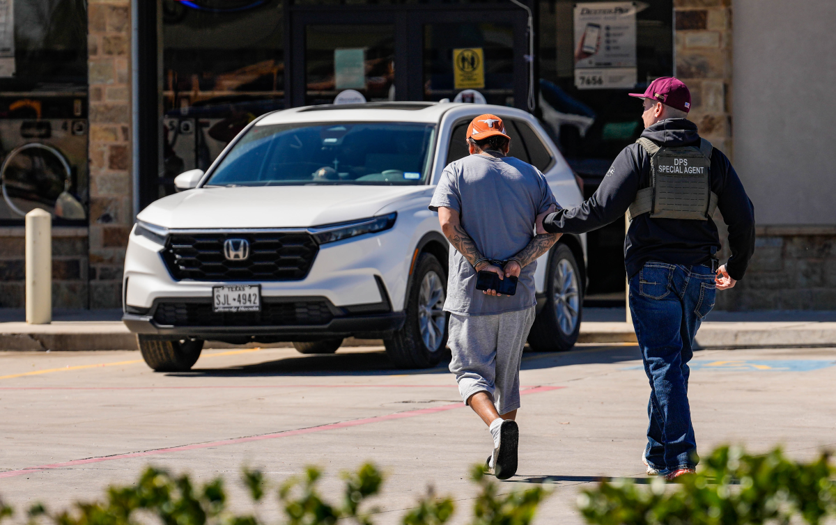 A man is detained by Federal agents as ICE conducts raids on Monday, Feb. 24, 2025. The Trump administration has cracked down on migrants, including many in the U.S. with legal status. Now the White House is exploring a proposal to deport American citizens to be jailed overseas.
