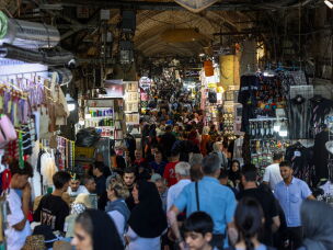 People walk past shops and browse for goods at the Grand Bazaar in Tehran on Aug. 24.