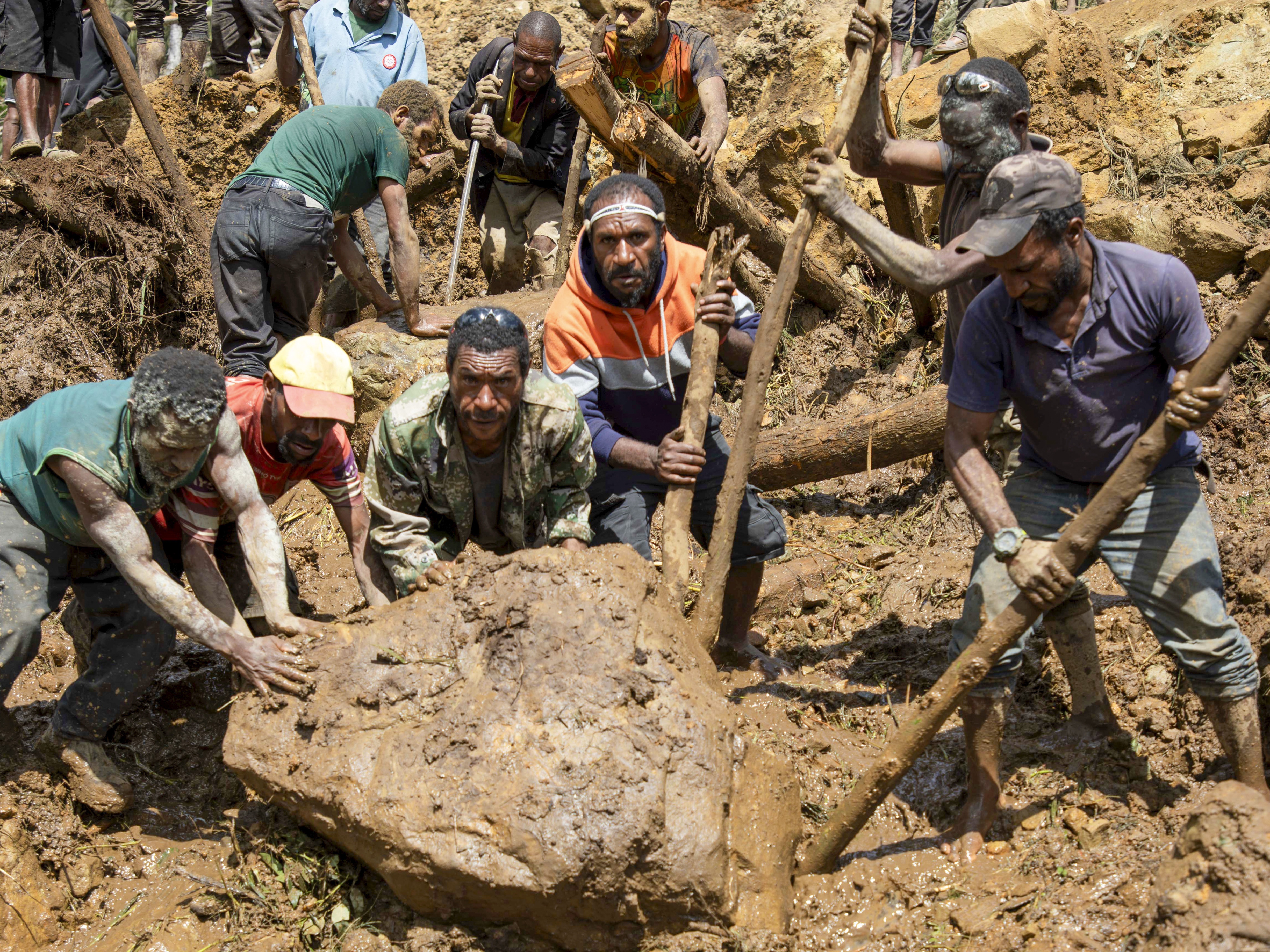 Villagers search through debris from a landslide in Yambali village in the highlands of Papua New Guinea, on Monday, May 27, 2024. Authorities fear a second landslide and a disease outbreak are looming at the scene because of water streams trapped beneath tons of debris and decaying corpses seeping downhill. 