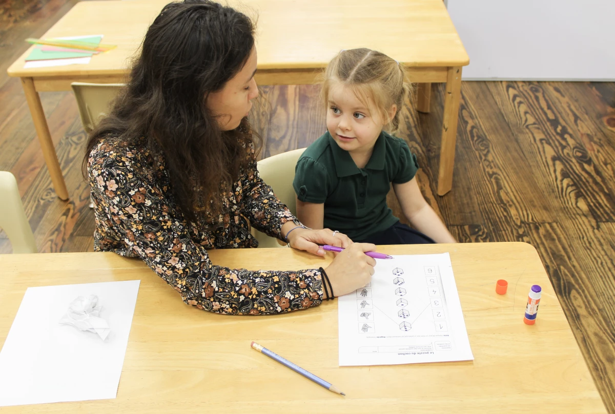 Camille Revillet's pre-K class practices math in French, counting boxes and drawing a line to the correct number.