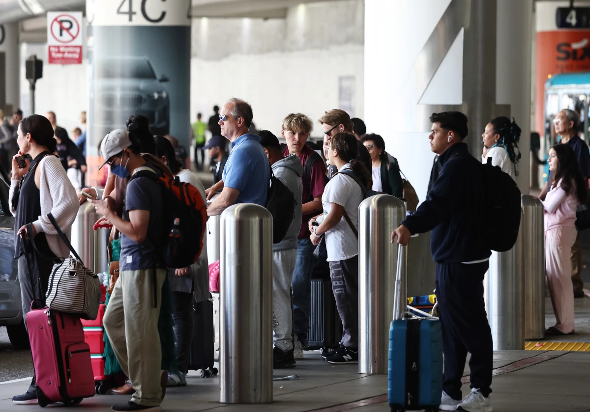 Travelers await rides at Los Angeles International Airport ahead of the Labor Day holiday on Friday.