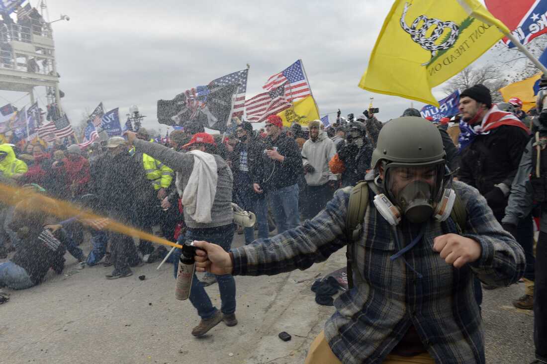 Rioters assault police protecting the U.S. Capitol on Jan. 6, 2021. The Trump administration has systematically tried to rewrite the history of the violent attack, including by purging information from government websites.