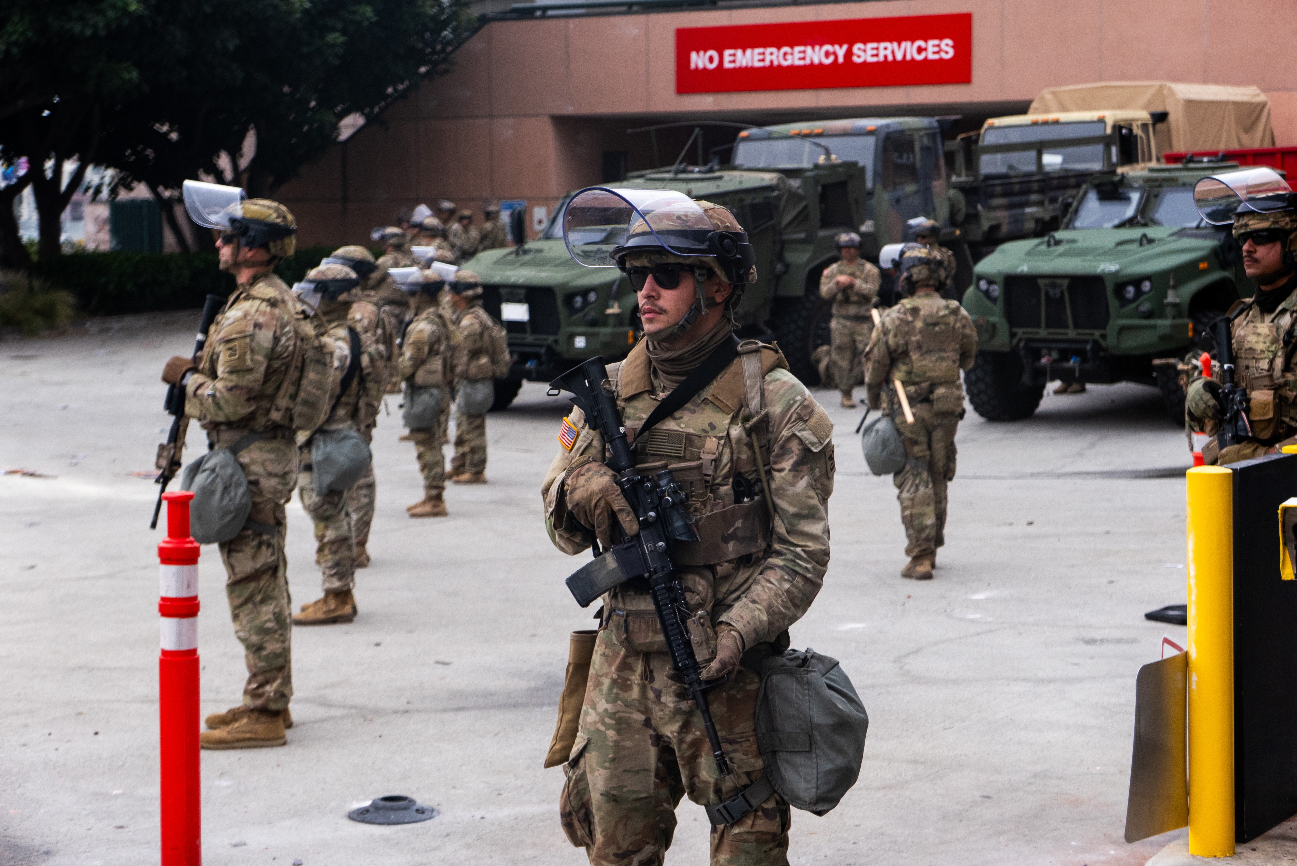 National Guard troops stand outside the Metropolitan Detention Center on Sunday in Los Angeles. Tensions in the city remain high after the Trump administration called in the National Guard against the wishes of city leaders following two days of clashes with police during a series of immigration raids.
