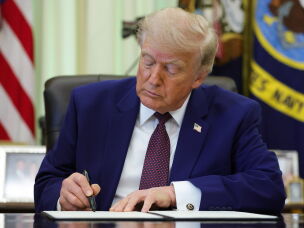 President Trump signs an executive order during an event in the Oval Office of the White House in June.